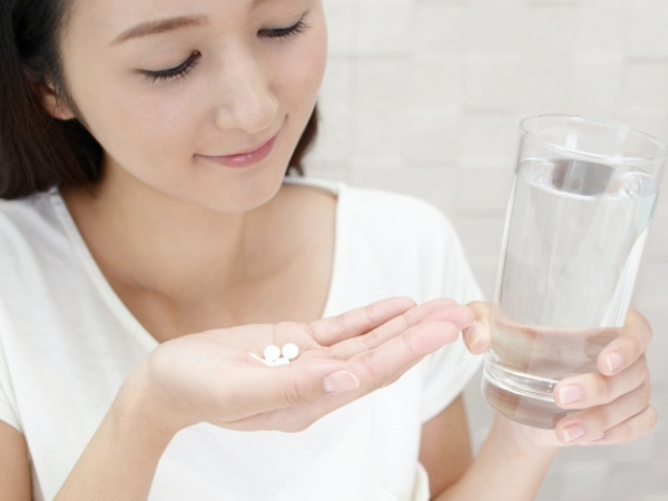 今から薬を飲もうとしている女性のイメージ画像